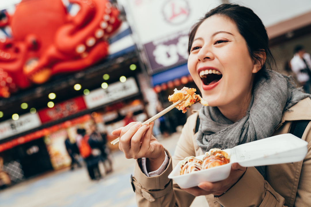 Happy young adult Asian woman tourist eating Asian food