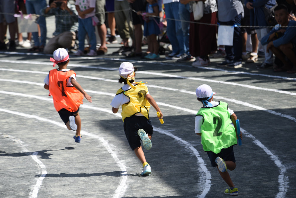 Three kids running on Sports Day in Japan