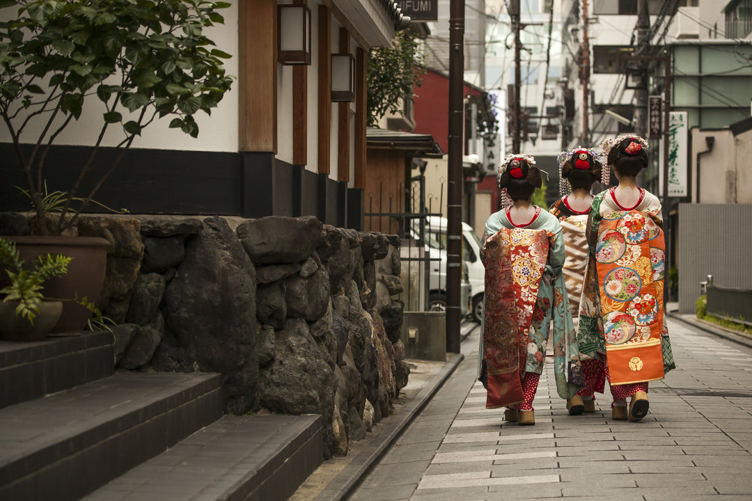 Geishas walking by an old street, Osaka, Japan